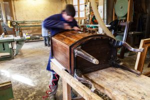 Carpenter restoring Wooden Furniture in his workshop